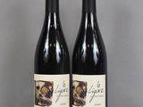 two bottles of wine sitting on top of a table next to each other