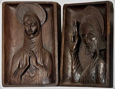 carvings of a woman and a man holding a candle in a wooden box
