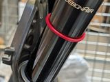a close up of a person ' s hand holding a black and red bicycle