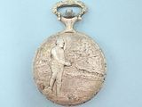 a silver pocket watch with a man playing golf on it