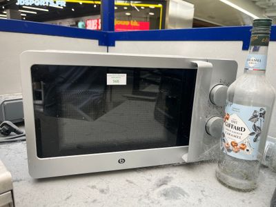 une bouteille de vodka posée à côté d'un micro-ondes sur un plan de travail