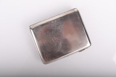 une image représentant un étui à cigarettes argenté posé sur une surface blanche