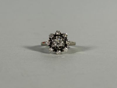 a close up of a white and black diamond ring on a white surface
