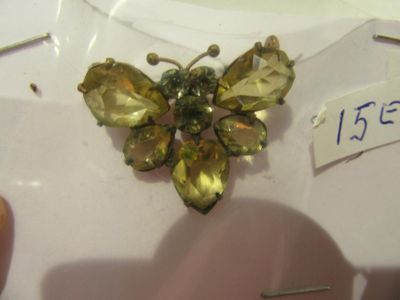 une petite broche en forme de papillon jaune posée sur une assiette blanche