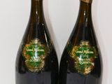 two bottles of champagne sitting next to each other on a white surface