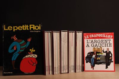 Plusieurs livres sont alignés sur une table devant un fond noir.