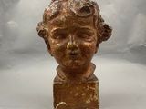 une image représentant la tête d'un enfant sculptée dans un bloc de marbre