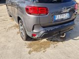the rear end of a silver car parked in a parking lot