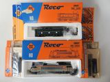 trois trains miniatures dans leurs boîtes sont empilés les uns sur les autres