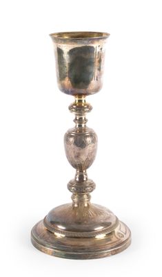 une coupe en argent posée sur un socle en bois