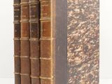 three old books sitting on top of each other on a white surface