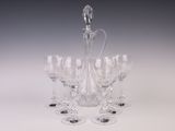 six verres à vin et une carafe posés sur une table