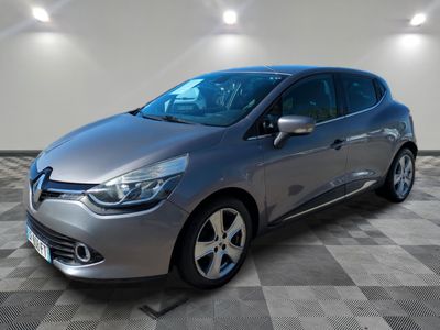 une voiture argentée est garée dans une pièce au sol en damier