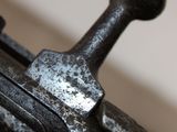 a close up of a metal object with a hammer on it