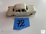 une petite voiture miniature avec une étiquette de prix posée sur la table