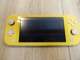 yellow nintendo switch lite sitting on top of a wooden table
