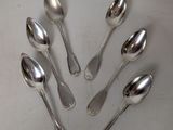 six silver spoons are arranged in a circle on a white surface