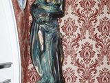 une statue représentant une femme tenant un bébé dans ses bras, posée sur un socle