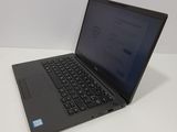 the laptop is sitting on a white table with a blue button