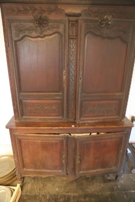 une grande armoire en bois sur laquelle sont posées de nombreuses assiettes