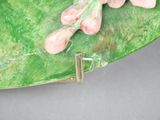 a close up of a green plate with a flower on it