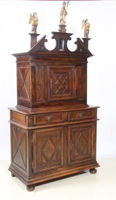 une grande armoire en bois à deux portes, surmontée d'une horloge