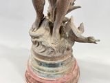 an image of a statue of a boy holding a bird on a pedestal