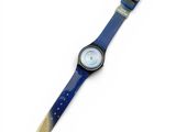 a close up of a watch on a white surface with a blue band