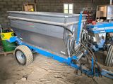 un tracteur bleu et une remorque bleue dans un bâtiment