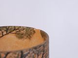 a close up of a vase with a tree design on it