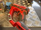 a red cordless drill and two other tools on a table