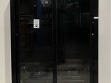 a black refrigerator with two doors open in a room