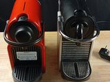 two coffee machines that are sitting on a table
