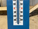 a thermometer that is on the side of a building