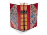 deux livres dans une bibliothèque rouge posée sur une surface blanche