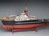 une maquette de bateau posée sur un socle, sur une surface grise