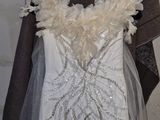 a wedding dress hanging on a hanger in a room
