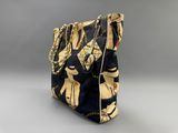 a close up of a black and gold purse with chains on it