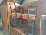 four chairs that are sitting on top of a wooden cabinet