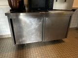 a stainless steel cabinet with a microwave on top of it