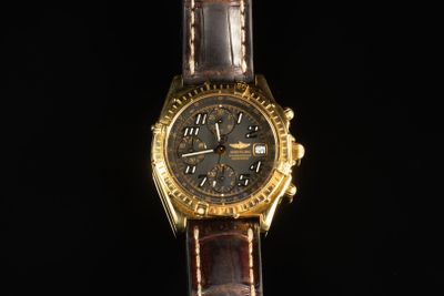 une image d'une montre en or avec un bracelet en cuir marron