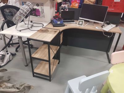 a desk with two computers and a chair in a room