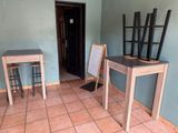 a room with a table, chairs, and a mirror