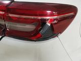 the rear end of a white car with a red tail light