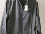 a grey jacket hanging on a wall next to a hanger
