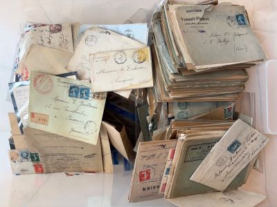 une pile de vieilles lettres et d'enveloppes dans une boîte posée sur une table