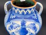 un vase bleu et blanc posé sur une surface noire