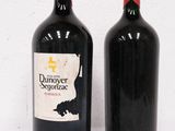 two bottles of wine sitting next to each other on a white surface