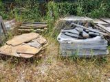 un tas de bois posé dans l'herbe à côté d'un tas de bûches