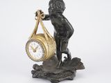 a statue of a boy holding a clock in his hand